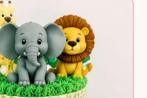 A jungle-themed cake topped with fondant elephant, lion and giraffe figures